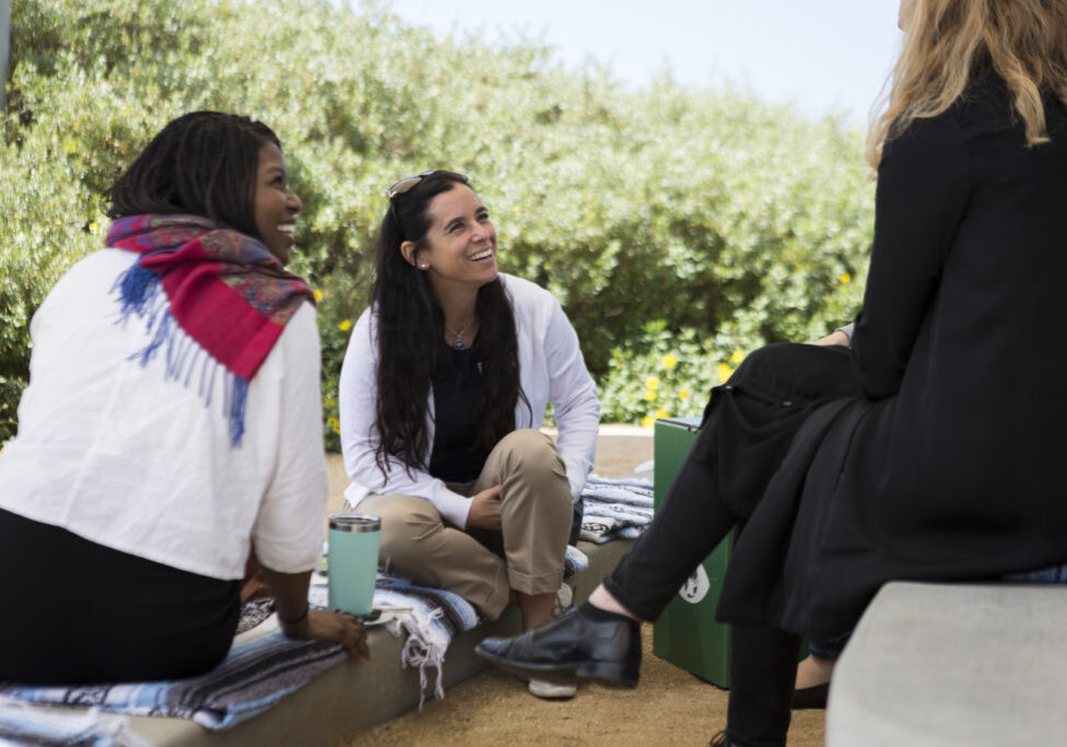 Women sit in conversation at a conference at the Tijuana Estuary Visitor Center