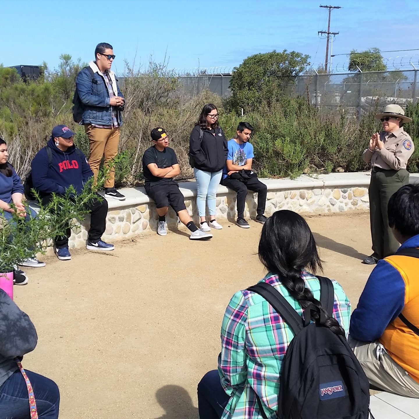 A group of students listen to a presentation by a California State Parks employee at the Tijuana Estuary